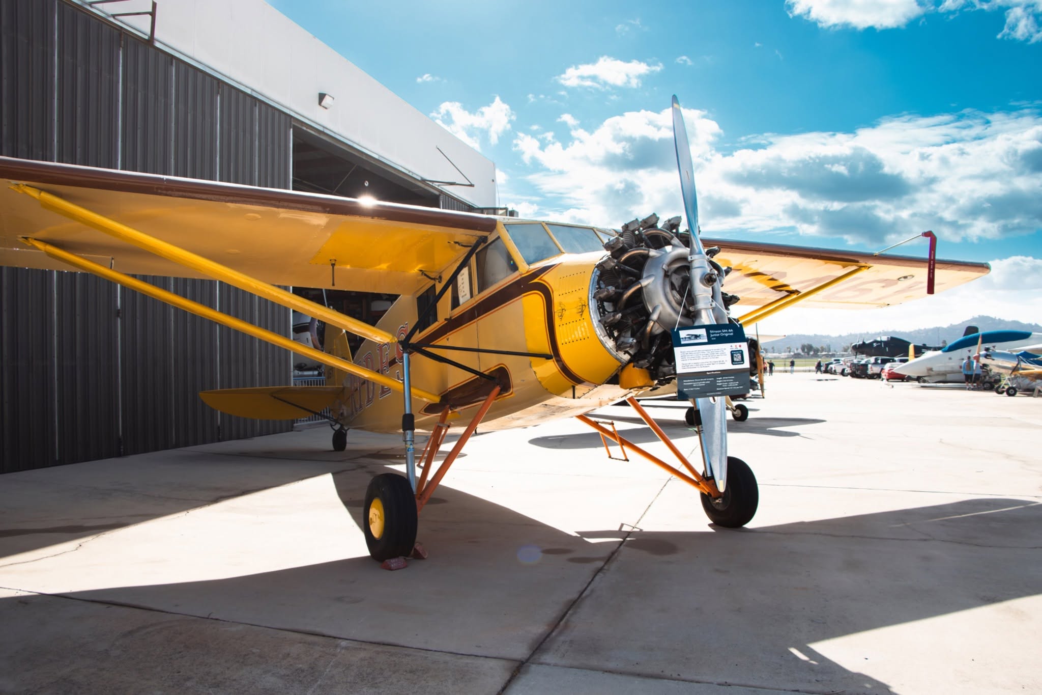 Restored vintage aircraft suspended and displayed inside the San Diego Air and Space Museum
