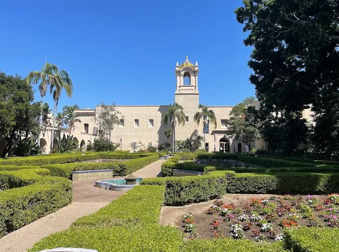 Visitors walking along El Prado between museum buildings in Balboa Park